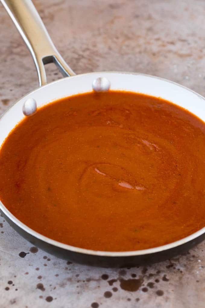 Chicken broth, seasonings and tomato sauce in a pan.