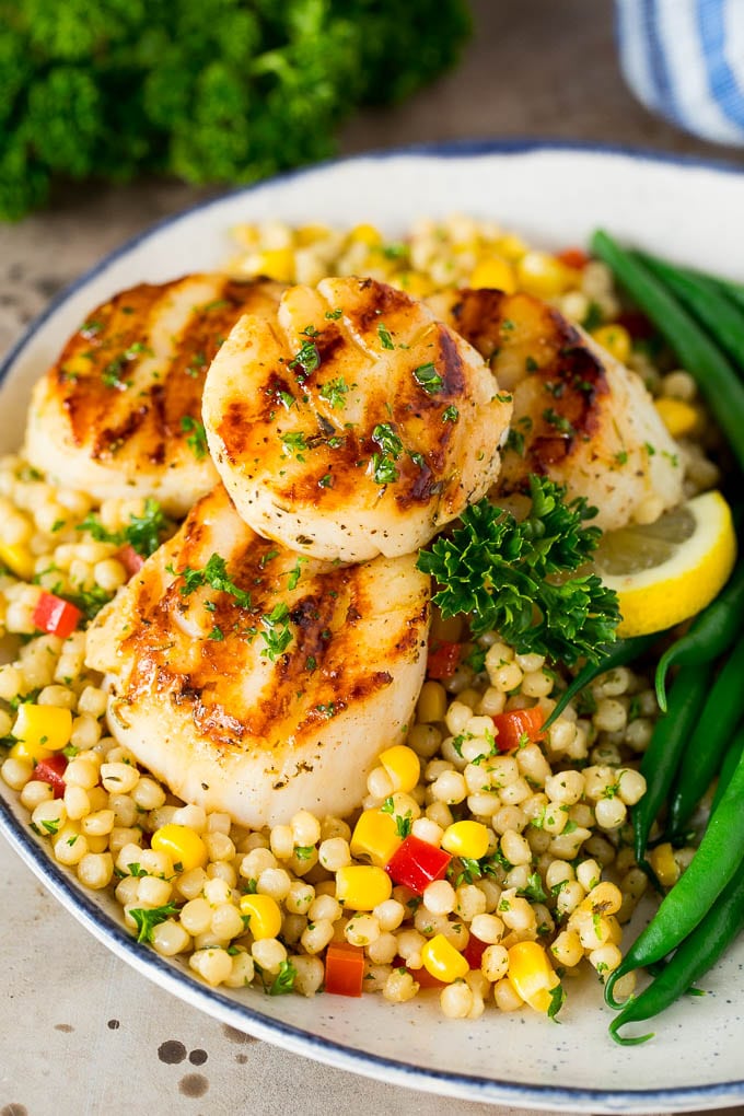 Grilled scallops served over couscous with green beans.