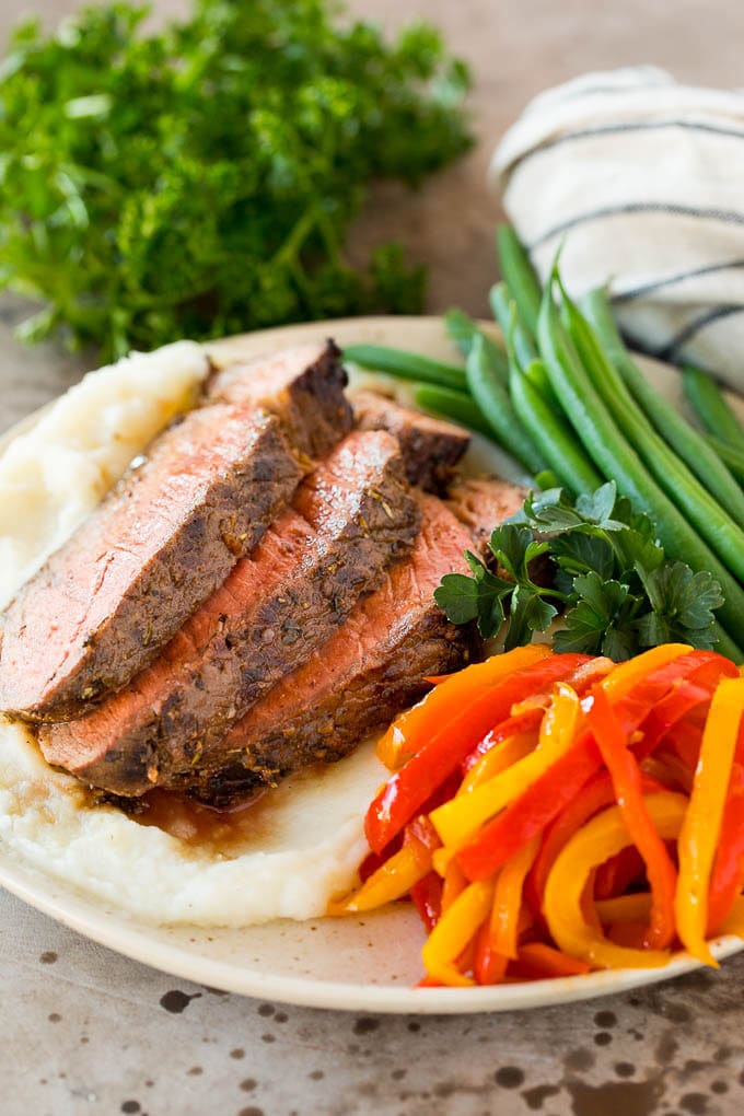 A plate of grilled beef, peppers and green beans.