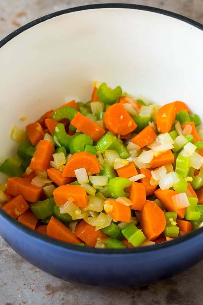 Cooked carrots, onions and celery in a pot.