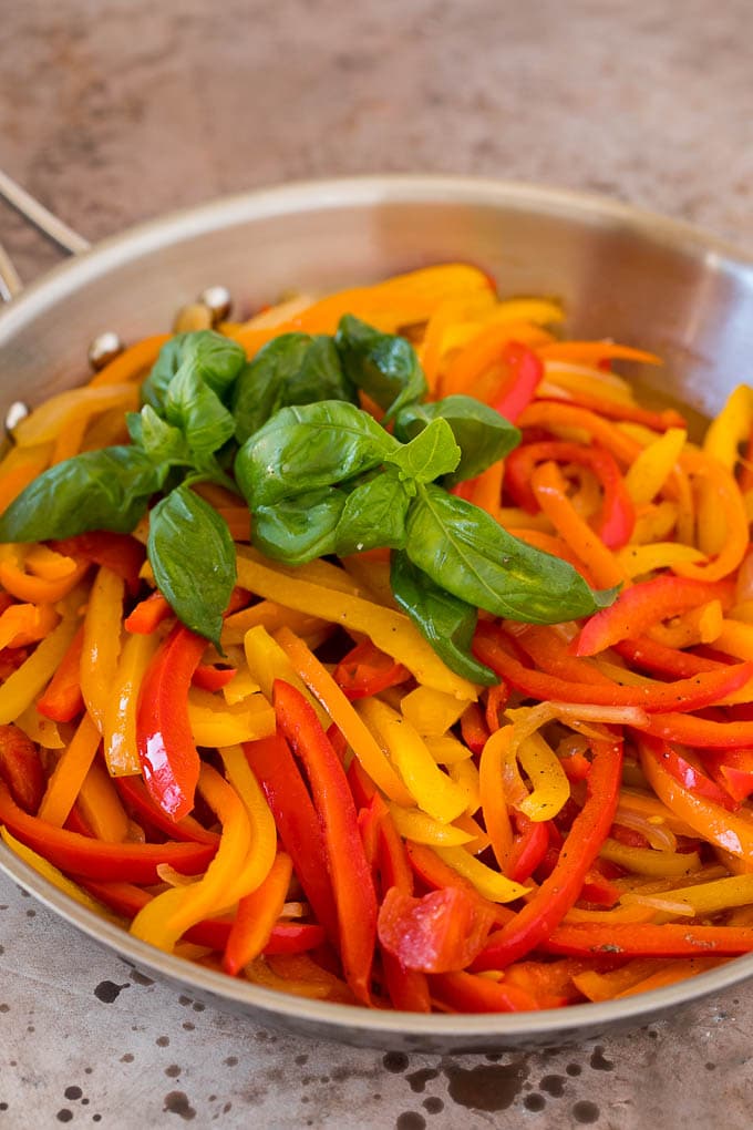 Stewed peppers and onions garnished with fresh basil.