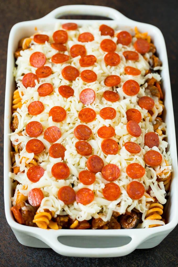 Pasta in a casserole dish topped with cheese and pepperoni.