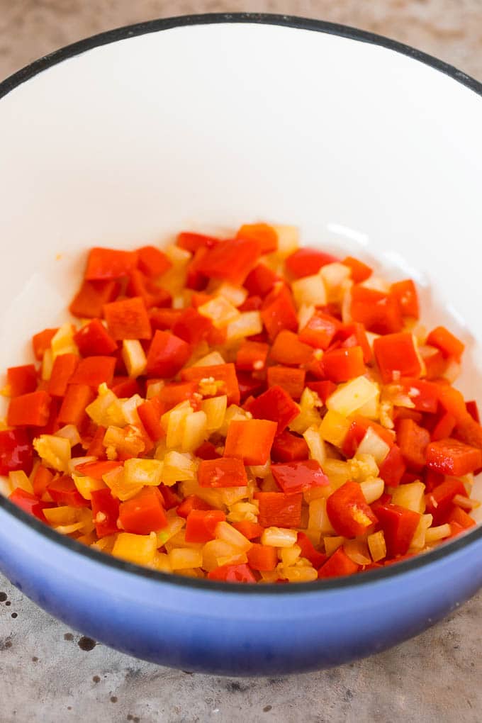 Sauteed peppers and onions in a pot.