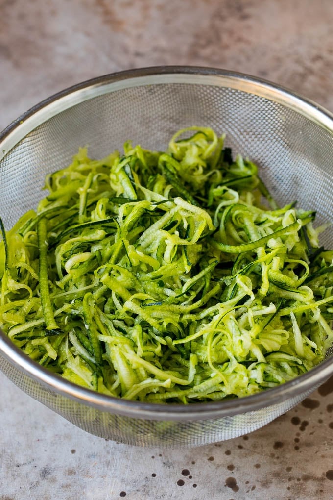 Shredded zucchini in a colander.