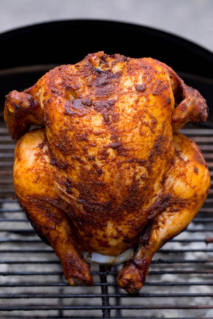 A beer can chicken coated in seasonings and grilled until done.