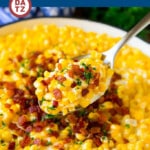 This creamed corn recipe consists of corn kernels simmered in cream sauce, then topped with crispy bacon and fresh herbs.