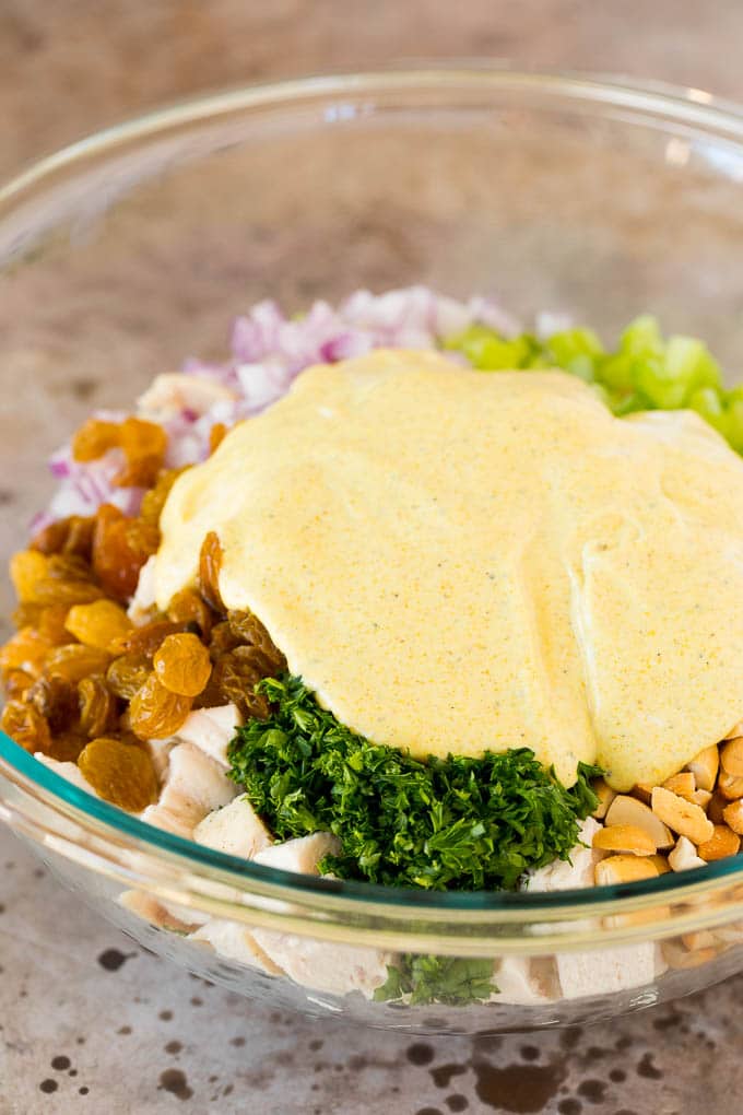 A bowl of chicken salad with creamy dressing poured over the top.