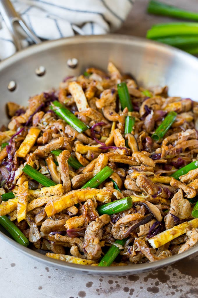 Moo shu pork with eggs, green onions and cabbage in a skillet.
