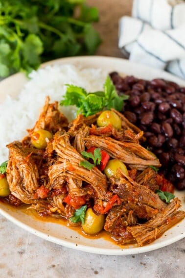 A plate of ropa vieja served with rice and black beans.