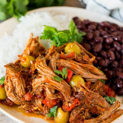A plate of ropa vieja served with rice and black beans.