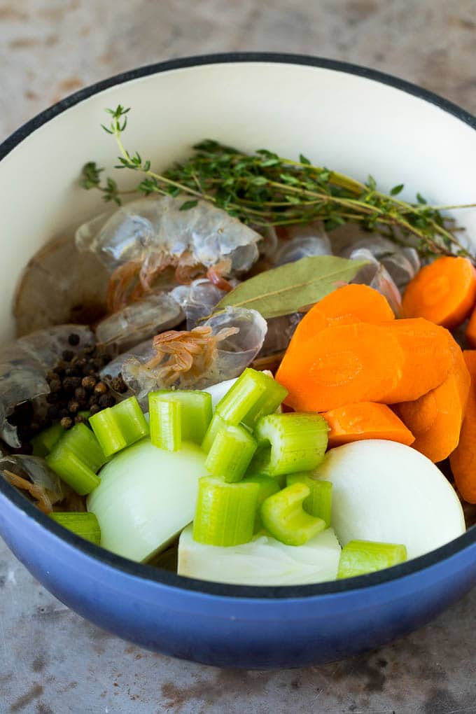 Shrimp shells, herbs and vegetables in a pot.