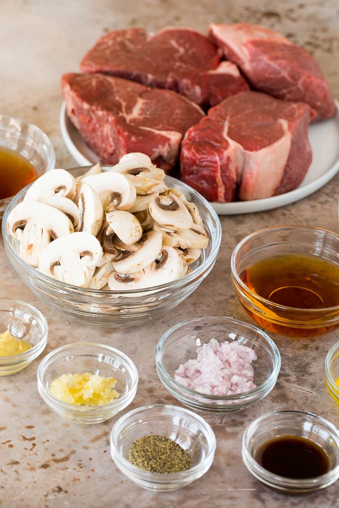 Bowls of ingredients including sliced mushrooms, shallots, garlic and seasonings.