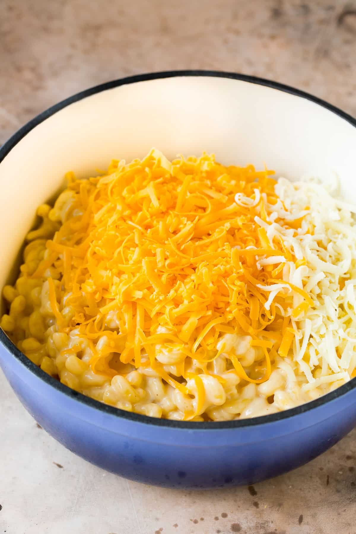 Cooked noodles with two types of shredded cheese on top.