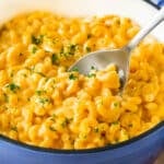 A pot of stovetop mac and cheese with a serving spoon in it.