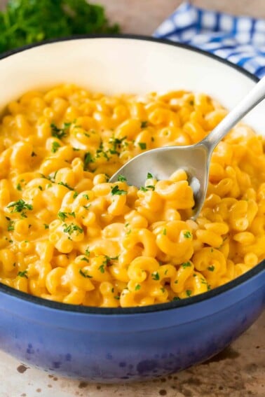 A pot of stovetop mac and cheese with a serving spoon in it.