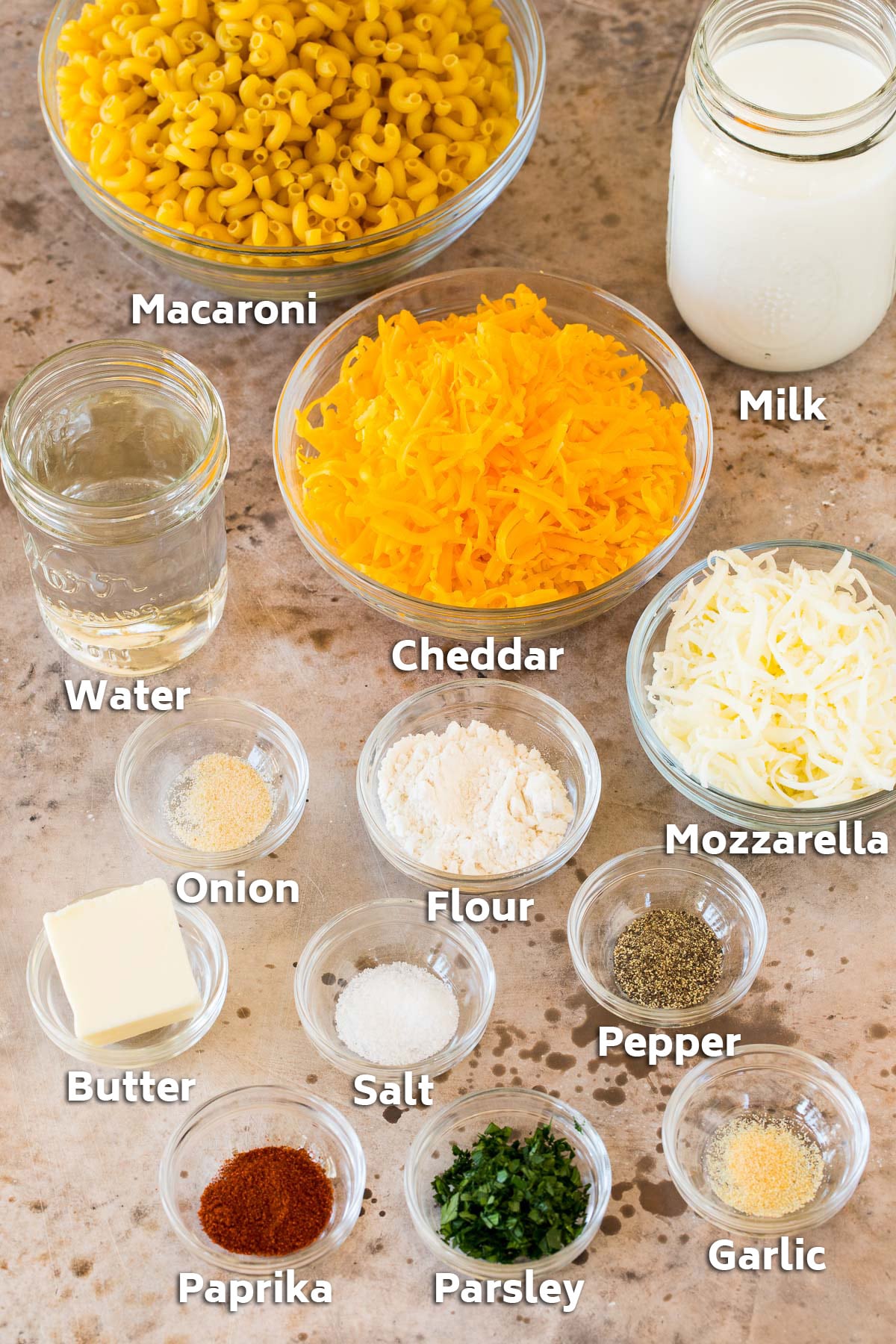 Bowls of ingredients including macaroni, cheeses and seasonings.