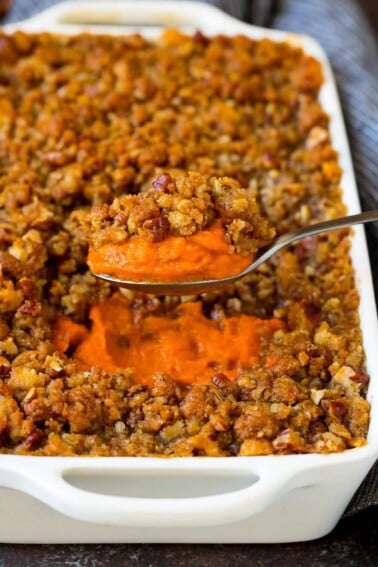 A spoon serving up a portion of sweet potato souffle.