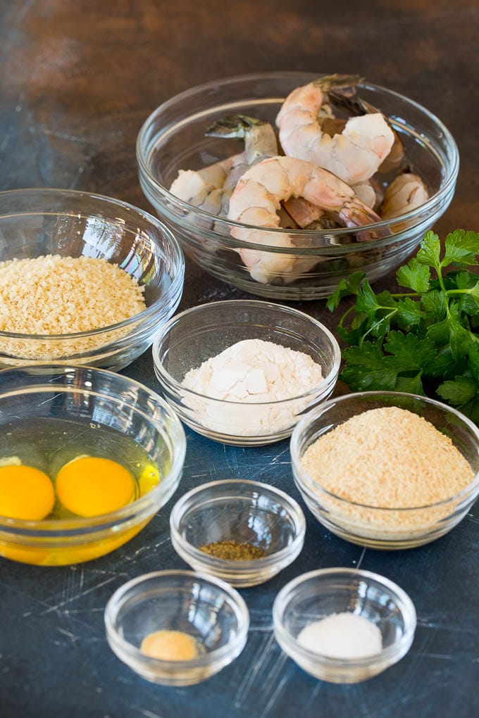 Bowls of breadcrumbs, seasonings and shrimp.