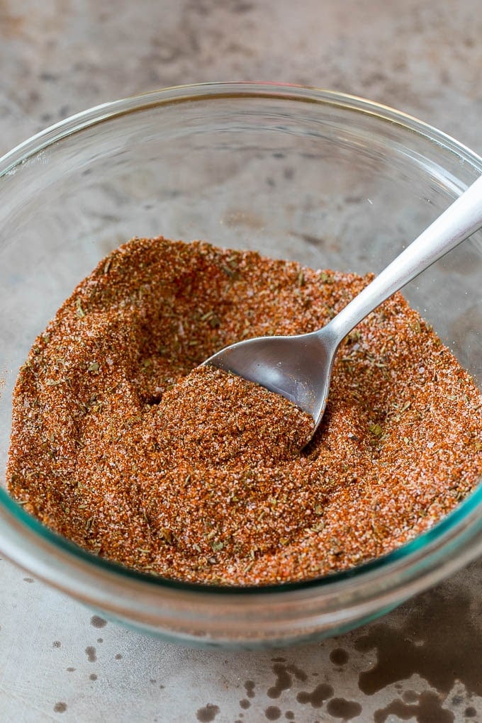 A bowl of blackened seasoning with a spoon in it.