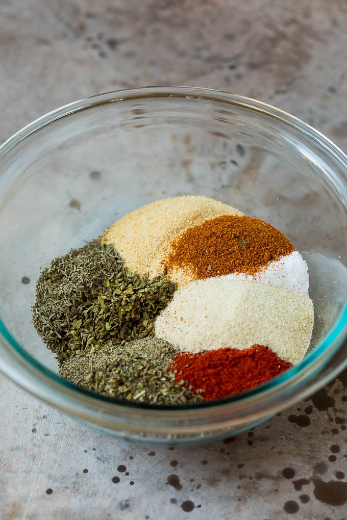 A mixing bowl filled with an assortment of spices and dried herbs.