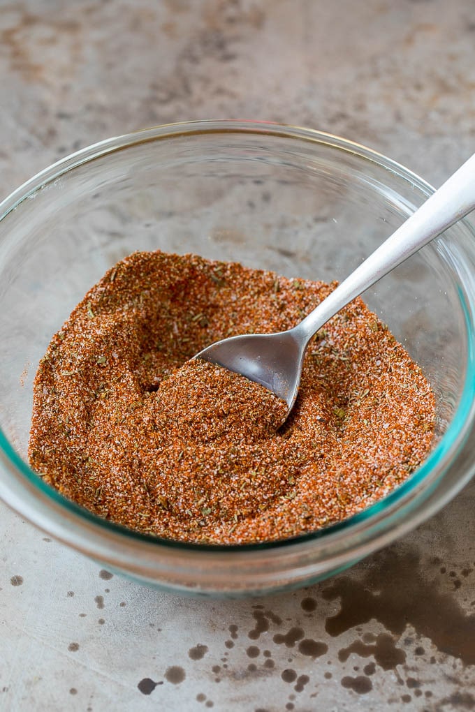 A mix ofspices in a bowl with a spoon.