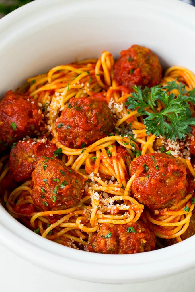 Crock pot spaghetti with meatballs, parmesan and fresh parsley.