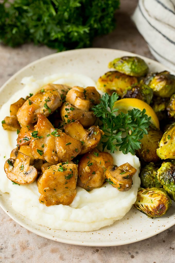Garlic butter chicken served with mashed potatoes and brussels sprouts.