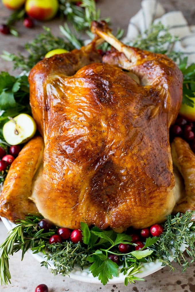 Learn how to brine a turkey to make this cooked turkey garnished with herbs.