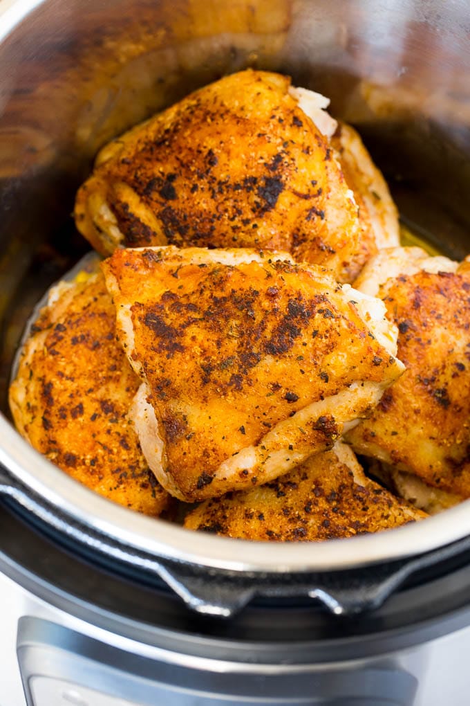 Seared chicken thighs in a pressure cooker.