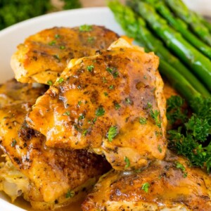Instant Pot chicken thighs with gravy, served with asparagus.