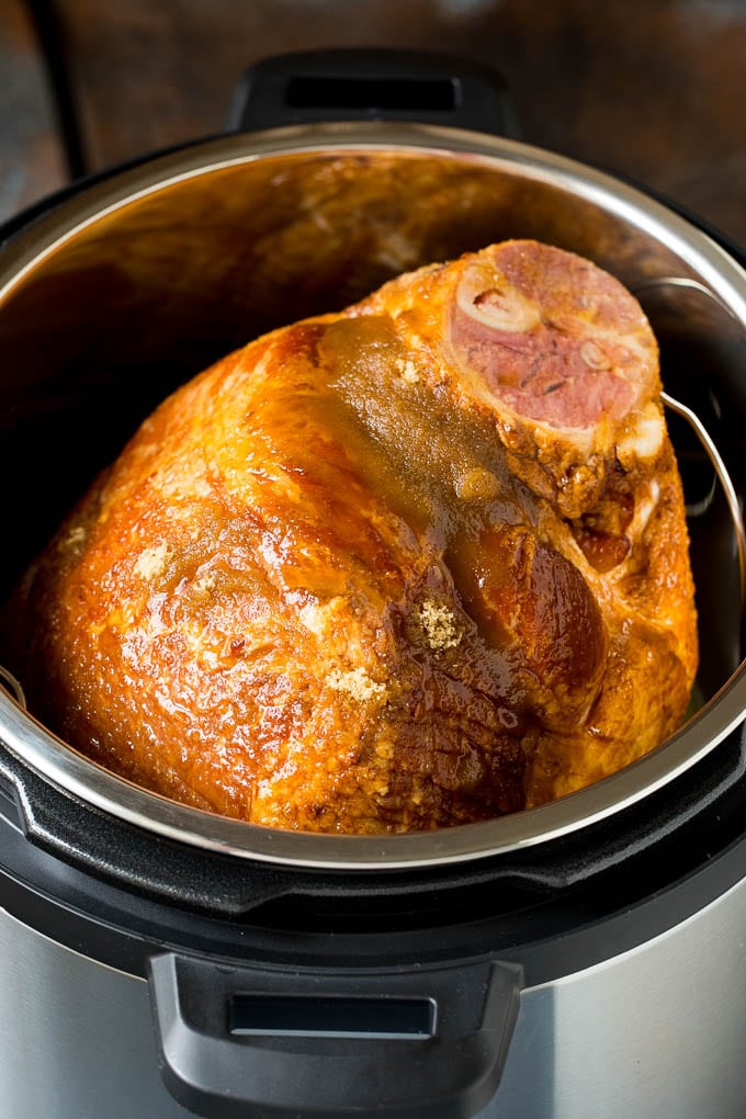 A ham coated in brown sugar and maple syrup in an Instant Pot.