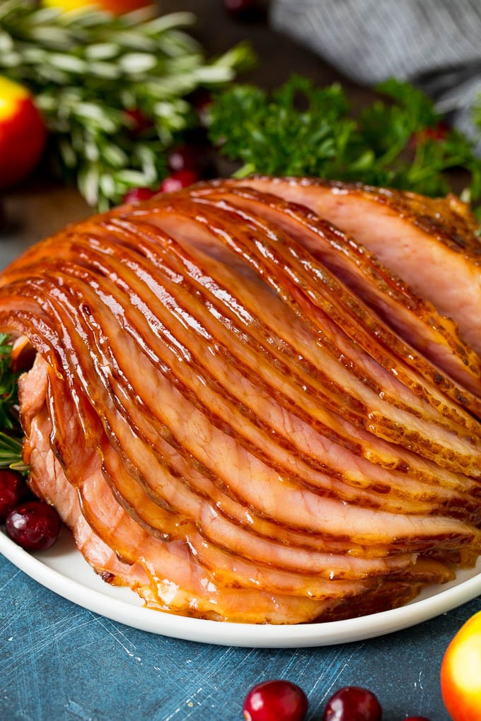 Sliced ham on a plate garnished with cranberries.