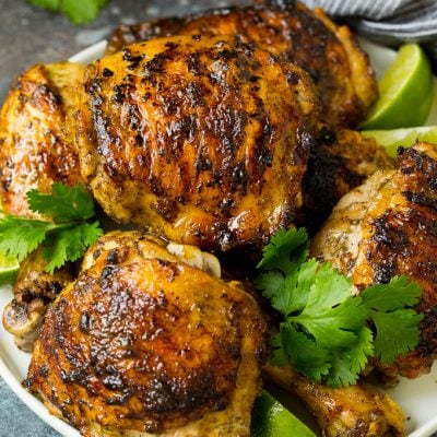 A plate of grilled chicken coated in jerk chicken marinade.