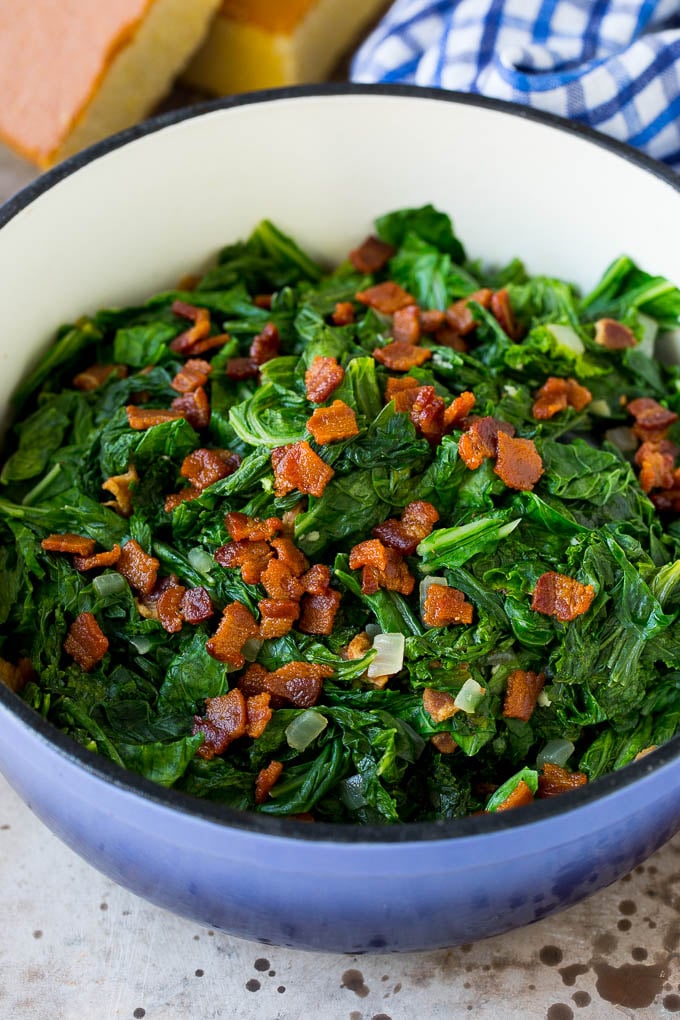 A pot of mustard greens topped with bacon.