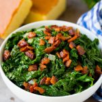 A bowl of mustard greens and bacon, served with cornbread.