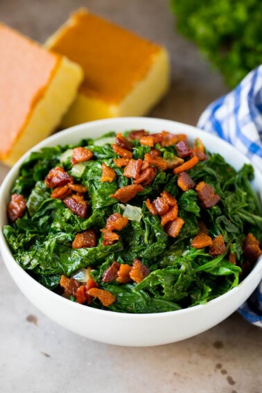 A bowl of mustard greens and bacon, served with cornbread.