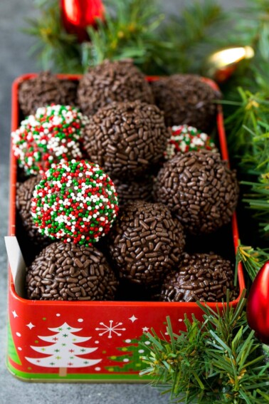 A tin of rum balls coated in holiday sprinkles.