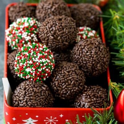 A tin of rum balls coated in holiday sprinkles.