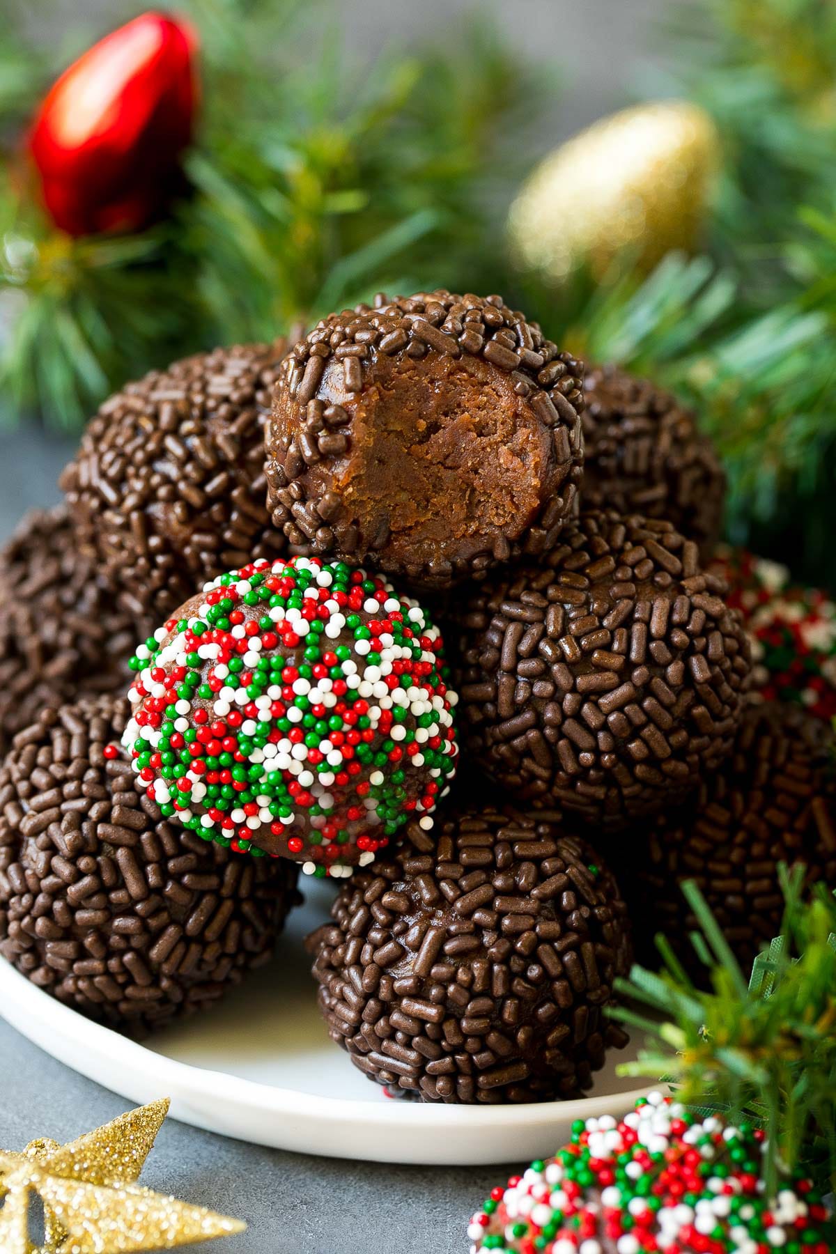 A plate of rum balls with holiday decorations around it.