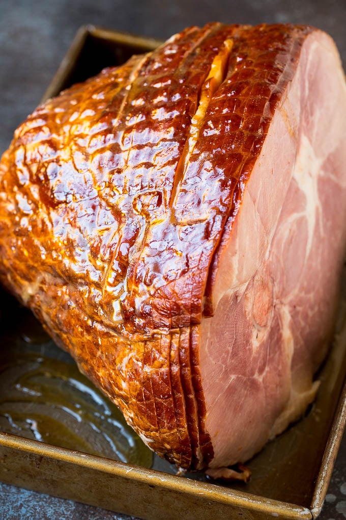 A ham in a baking pan coated in glaze.