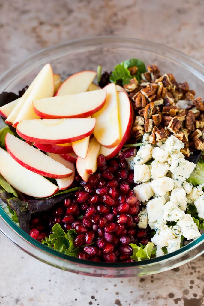 Lettuce topped with apples, blue cheese, pecans and pomegranate seeds.