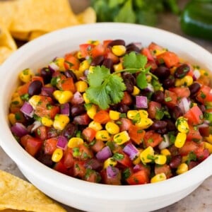 A bowl of black bean and corn salsa with tortilla chips.