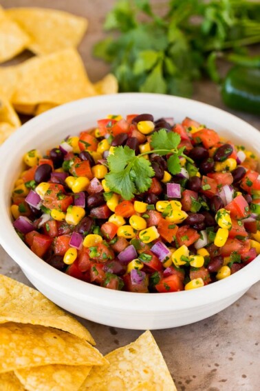 A bowl of black bean and corn salsa with tortilla chips.