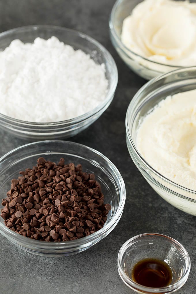 Bowls of mini chocolate chips, ricotta cheese, mascarpone, powdered sugar and vanilla extract.