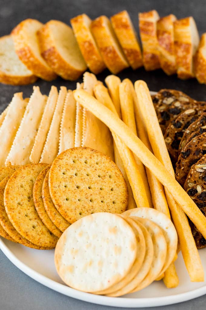 A plate of crackers and breadsticks.