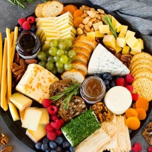 The best cheese board with assorted cheeses, bread, crackers, fruit and nuts.