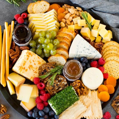 The best cheese board with assorted cheeses, bread, crackers, fruit and nuts.