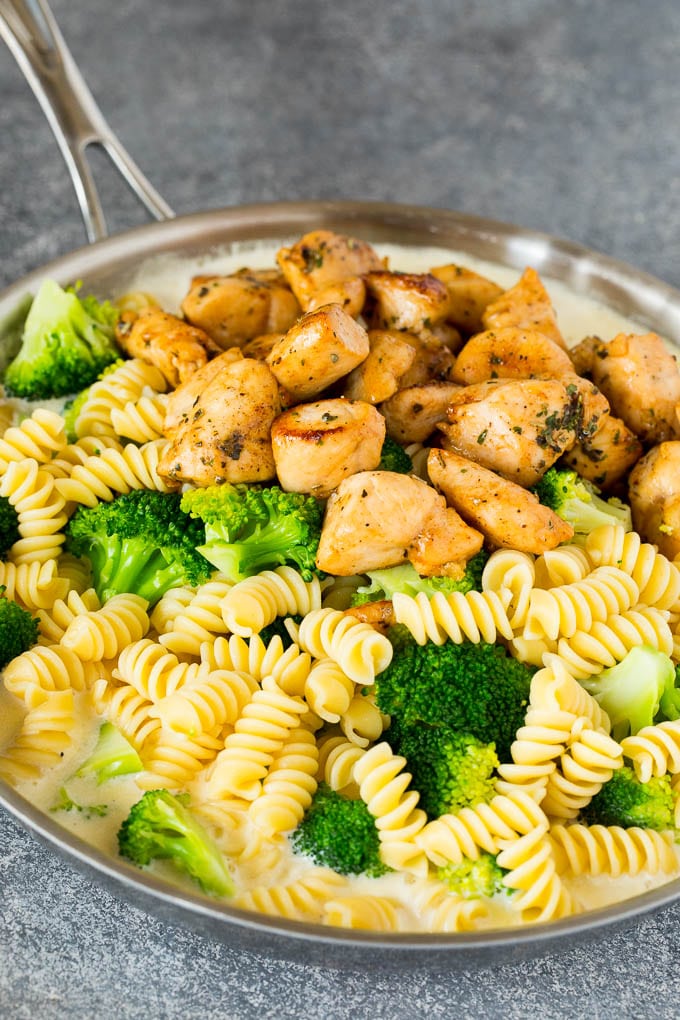 Chicken, pasta and broccoli in a pan of cream sauce.