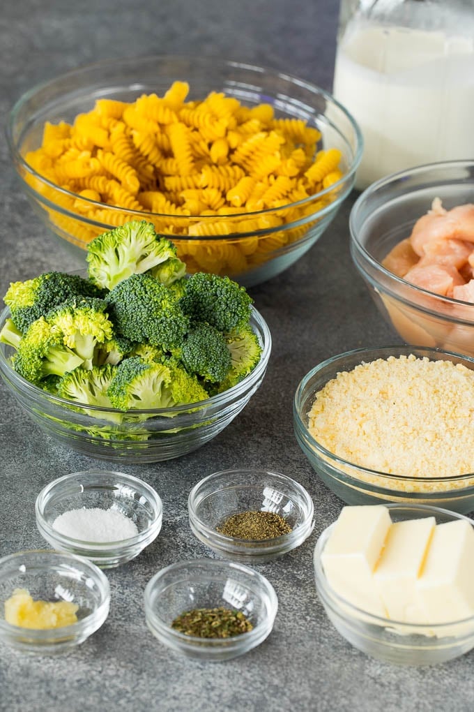 Bowls of ingredients including pasta, chicken, broccoli, butter and cheese.