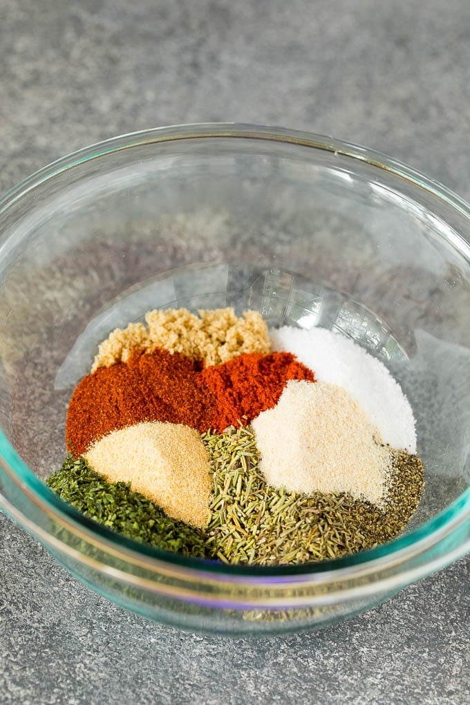 A mixing bowl with salt, pepper, dried herbs and spices.